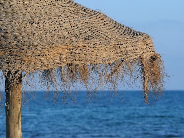 Ombrellone in vimini sulla spiaggia