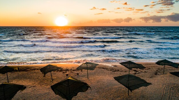 Ombrelloni da spiaggia all'alba. La corrente marina nuota contro le onde sul bellissimo mare