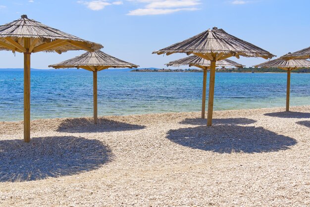 Ombrelloni di paglia sulla spiaggia Spiagge vuote durante la quarantena spiaggia di lusso Mancanza di turisti