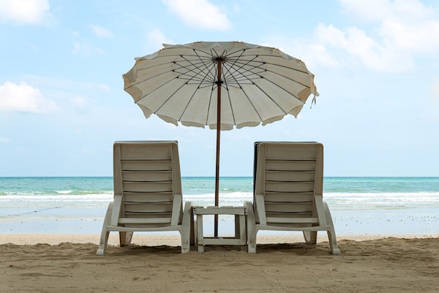 Ombrelloni e lettini sulla sabbia Nuvola bianca prende il sole sulla spiaggia Il concetto di riposo mare e vacanza