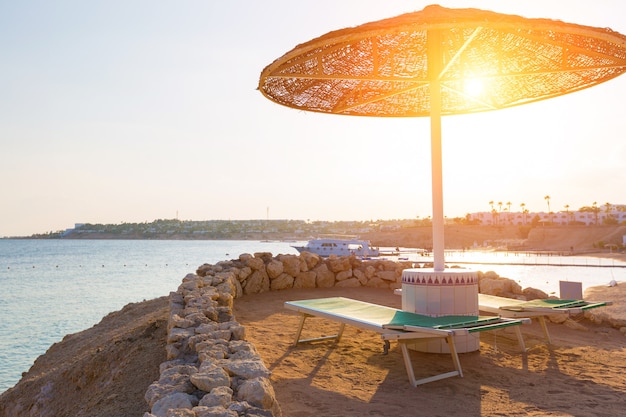 Ombrelloni e sdraio vuote in spiaggia durante il tramonto