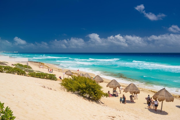 Ombrelloni su una spiaggia sabbiosa con acqua azzurra in una giornata di sole vicino a Cancun in Messico
