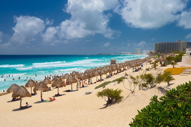 Ombrelloni su una spiaggia sabbiosa con acqua azzurra in una giornata di sole vicino a Cancun in Messico