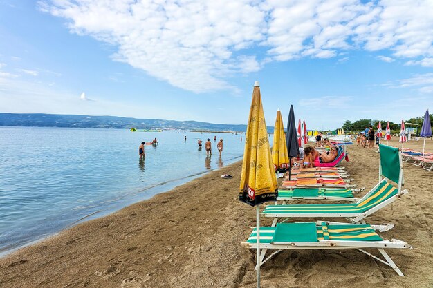 Omis, Croazia - 18 agosto 2016: Lettini con rifugi e persone sulla spiaggia di Omis, Croazia