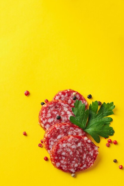 Ã Â¡oncept di cibo gustoso con salame su sfondo giallo