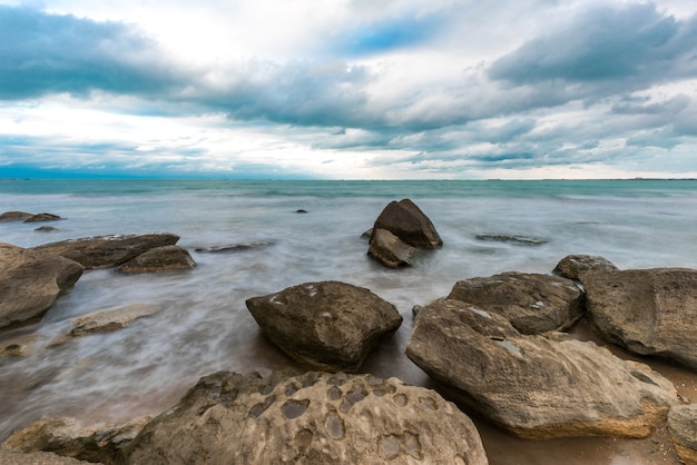 Onda che spruzza la freschezza delle rocce sulla spiaggia