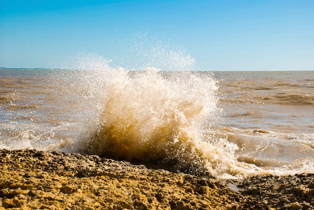 Onda con spray che si schianta sulla roccia