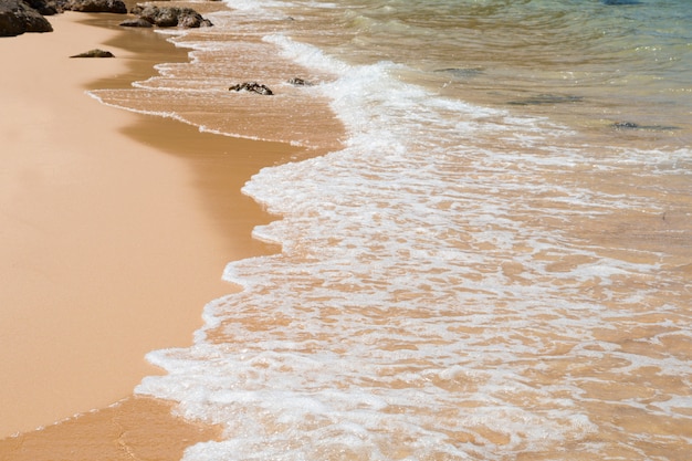 Onda del mare blu sulla spiaggia sabbiosa