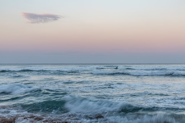 Onda del mare sulla riva al tramonto