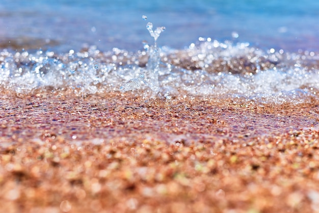 Onda del mare sulla spiaggia di sabbia, soft focus. Estate