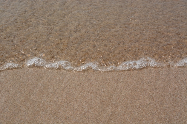 onda del mare sullo sfondo di sabbia