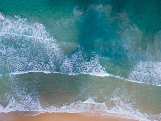 Onda di acqua di mare cristallina della spiaggia di vista superiore sulla spiaggia sabbiosa. Sfondo e concetto di viaggio.