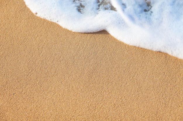 Onda di sfondo estivo del mare sulla spiaggia sabbiosa