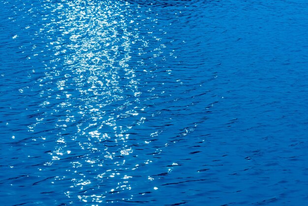 Ondate d'acqua blu sulla superficie ondulazioni sfocate sfocato sfocato trasparente blu colore chiaro calma
