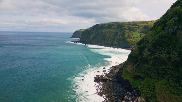 Ondate schiumose che rompono le colline vista del drone paesaggio costiero cupo surf dell'oceano