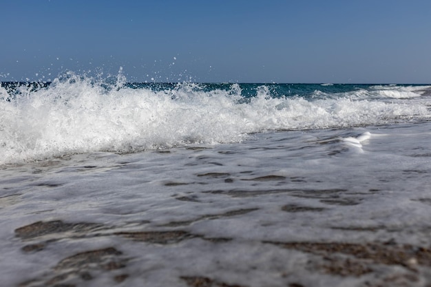 onde bianche nel mare blu sulla spiaggia