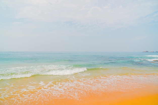 Onde blu dell&#39;oceano e sabbia gialla della spiaggia.