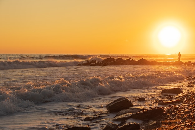 Onde blu scuro contro il bellissimo tramonto arancione sul Mar Nero, Anapa, Russia