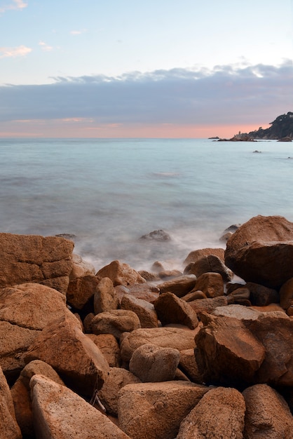 Onde che si infrangono nelle rocce del mare in un tramonto primaverile