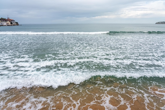 Onde che si infrangono sulla spiaggia di San Lorenzo nella città di Gijon nelle Asturie