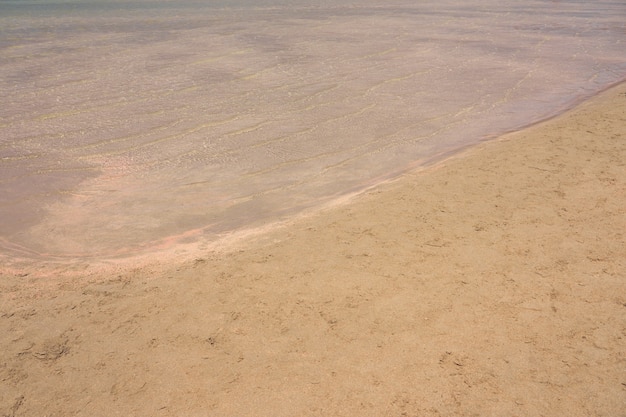 Onde chiare e sabbia colorata sulla spiaggia di sabbia tropicale in Creta Grecia.