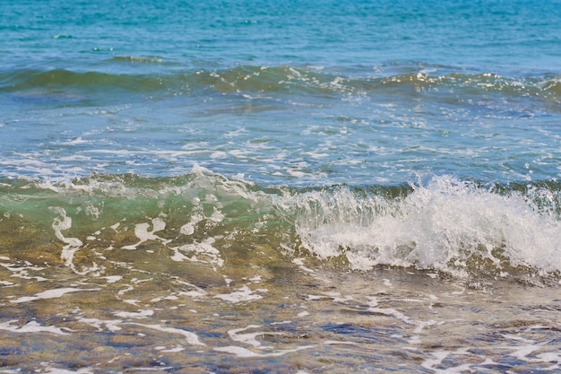 Onde con schiuma sulla costa del Mar Egeo in Creta Grecia.