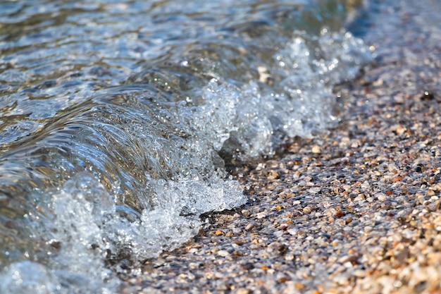 Onde del mare che si infrangono sulla riva di ciottoli.