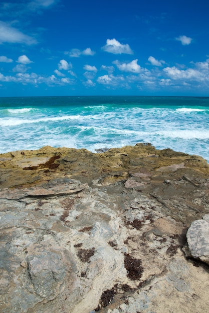 Onde del mare che si infrangono sulle rocce sulla spiaggia di pietra selvaggia in Messico. Relax sul mare tropicale