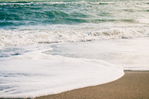 Onde del mare e sabbia sulla spiaggia in colori retrò