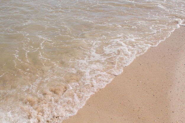 Onde del mare su una spiaggia sabbiosa nel pomeriggio