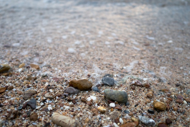 Onde del mare sulla spiaggia con pieno di pietre