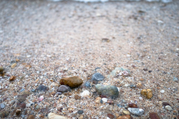 Onde del mare sulla spiaggia con pieno di pietre