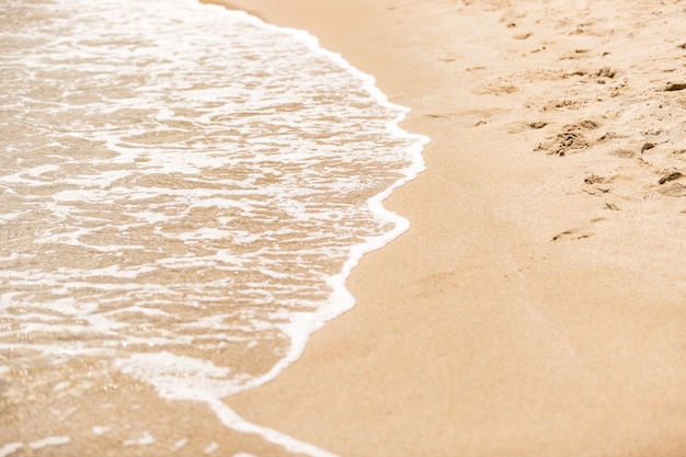 Onde del mare sulla spiaggia sabbiosa dell'isola tropicale