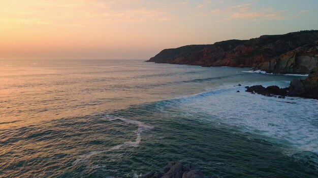 Onde dell'oceano tramonto spiaggia natura acqua di mare spruzzi di scogliere ruvide costa serale