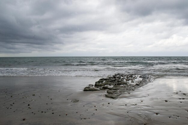 Onde della costa della spiaggia nuvolosa