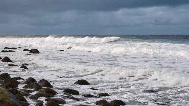 Onde di schiuma bianca corrono sulla costa rocciosa del mare bianco Mare nordico di Barents oceano