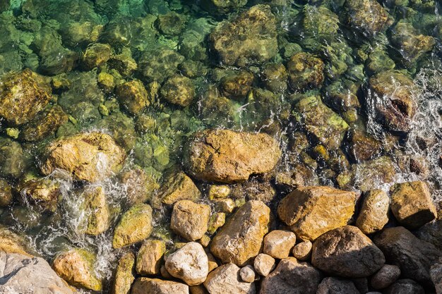 Onde di superficie del mare che si infrangono sulle rocce Rocce di sfondo del mare bellissimo