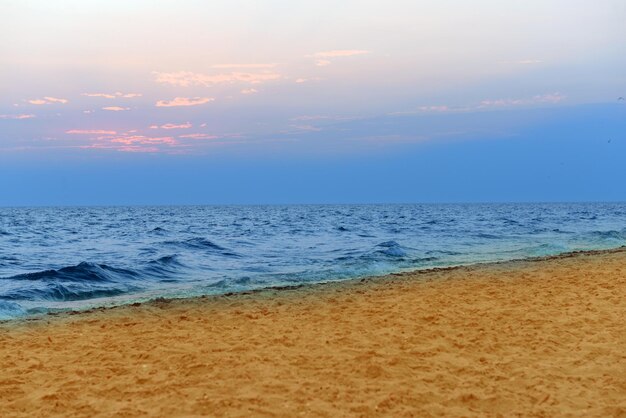 Onde e cielo della riva di mare al tramonto