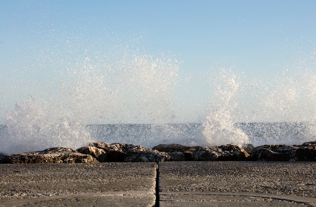 Onde schizzate sulle rocce in una giornata molto ventosa al tramonto