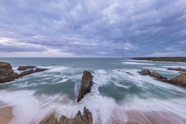 onde sulla costa delle Asturie al tramonto in una giornata invernale