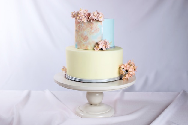 Opera d'arte. Torta nuziale decorata in stile pastello con fiori rosa