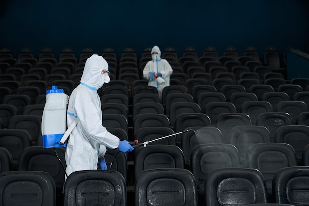 Operai che puliscono la sala cinematografica con disinfettanti speciali.