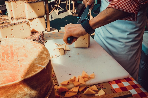 Operaio affettare il formaggio Primo piano di taglio del formaggio