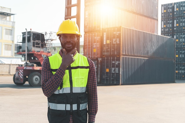 Operaio afroamericano nella stazione di carico di container import export di grandi carichi di spedizione