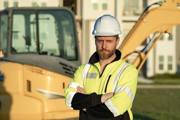 Operaio con bulldozer sulla costruzione del sito Lavoratore dell'escavatore uomo Operaio edile con escavatore sullo sfondo Operaio edile con trattore o veicolo da costruzione all'edificio