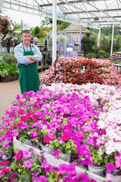 Operaio del Garden Center che sta accanto ai fiori