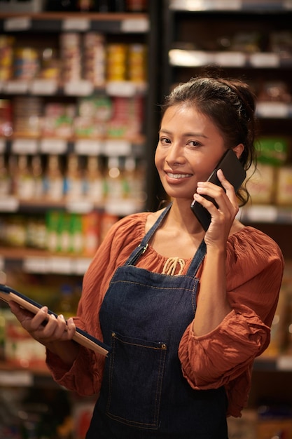 Operaio del supermercato che accetta l'ordine sul telefono