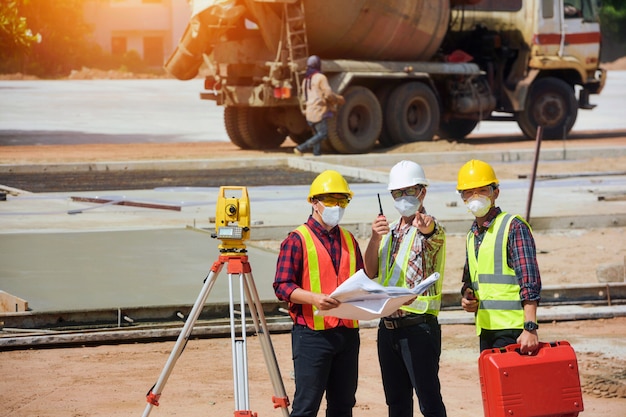 Operaio dell'ingegnere geometra che effettua la misurazione con teodolite sui lavori stradali. ingegnere di rilievo in cantiere.