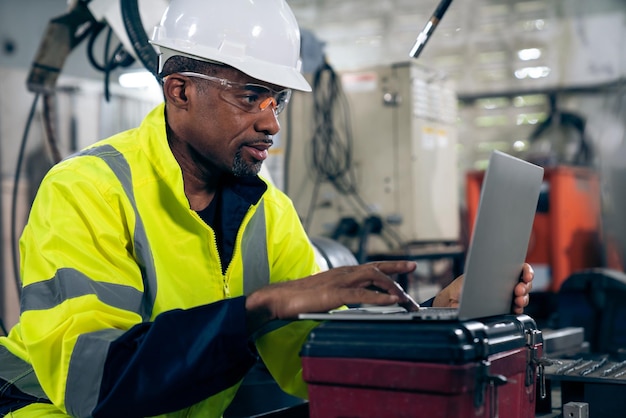 Operaio di fabbrica che lavora con un computer portatile per eseguire un'adeguata lista di controllo della procedura