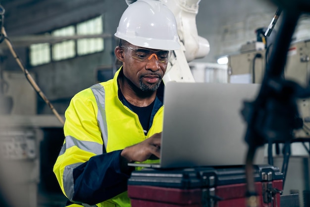 Operaio di fabbrica che lavora con un computer portatile per eseguire un'adeguata lista di controllo della procedura